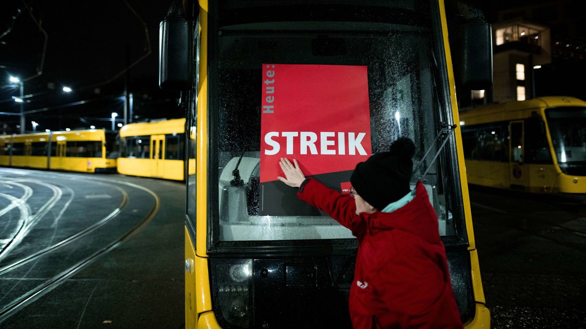 Eine Mitarbeiterin klebt ein Poster, auf dem "Heute: STREIK" steht, auf eine Trambahn im Depot der Ruhrbahn in Essen (Archivfoto)