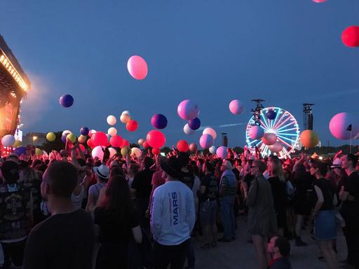 Fans bei Rock im Park mit Luftballons und Riesenrad. 