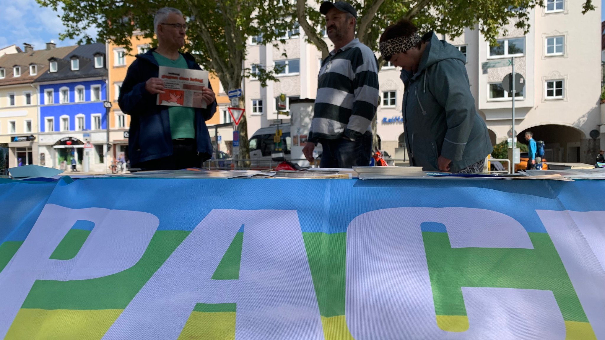 Besucher am Info-Stand der Traunsteiner Friedensinitiative, im Vordergrund PACE-Flagge | Bild: Hans Häuser /BR Besucher am Info-Stand der Traunsteiner Friedensinitiative, im Vordergrund PACE-Flagge