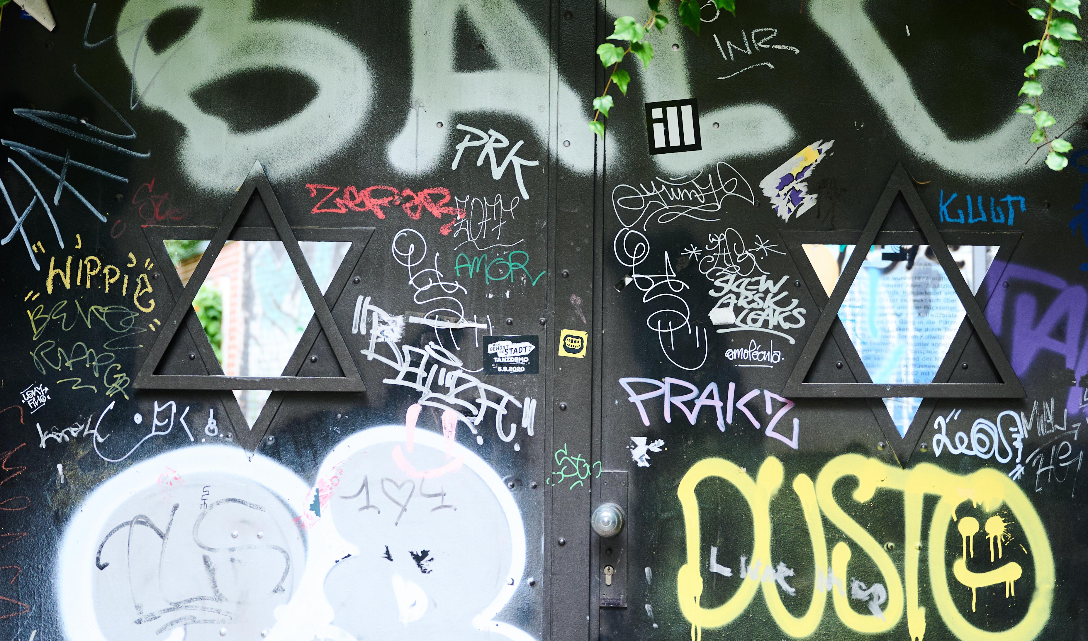 Das Eingangstor des Judengangs am jüdischen Friedhof Schönhauser Allee ist neben den beiden Fenstern in Form von Davidsternen, beschmiert. 