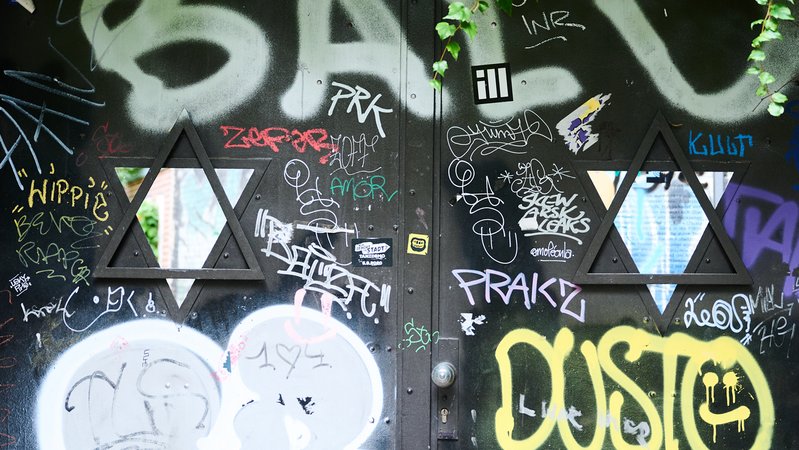 Das Eingangstor des Judengangs am jüdischen Friedhof Schönhauser Allee ist neben den beiden Fenstern in Form von Davidsternen, beschmiert. | Bild: picture alliance/dpa | Annette Riedl Das Eingangstor des Judengangs am jüdischen Friedhof Schönhauser Allee ist neben den beiden Fenstern in Form von Davidsternen, beschmiert.