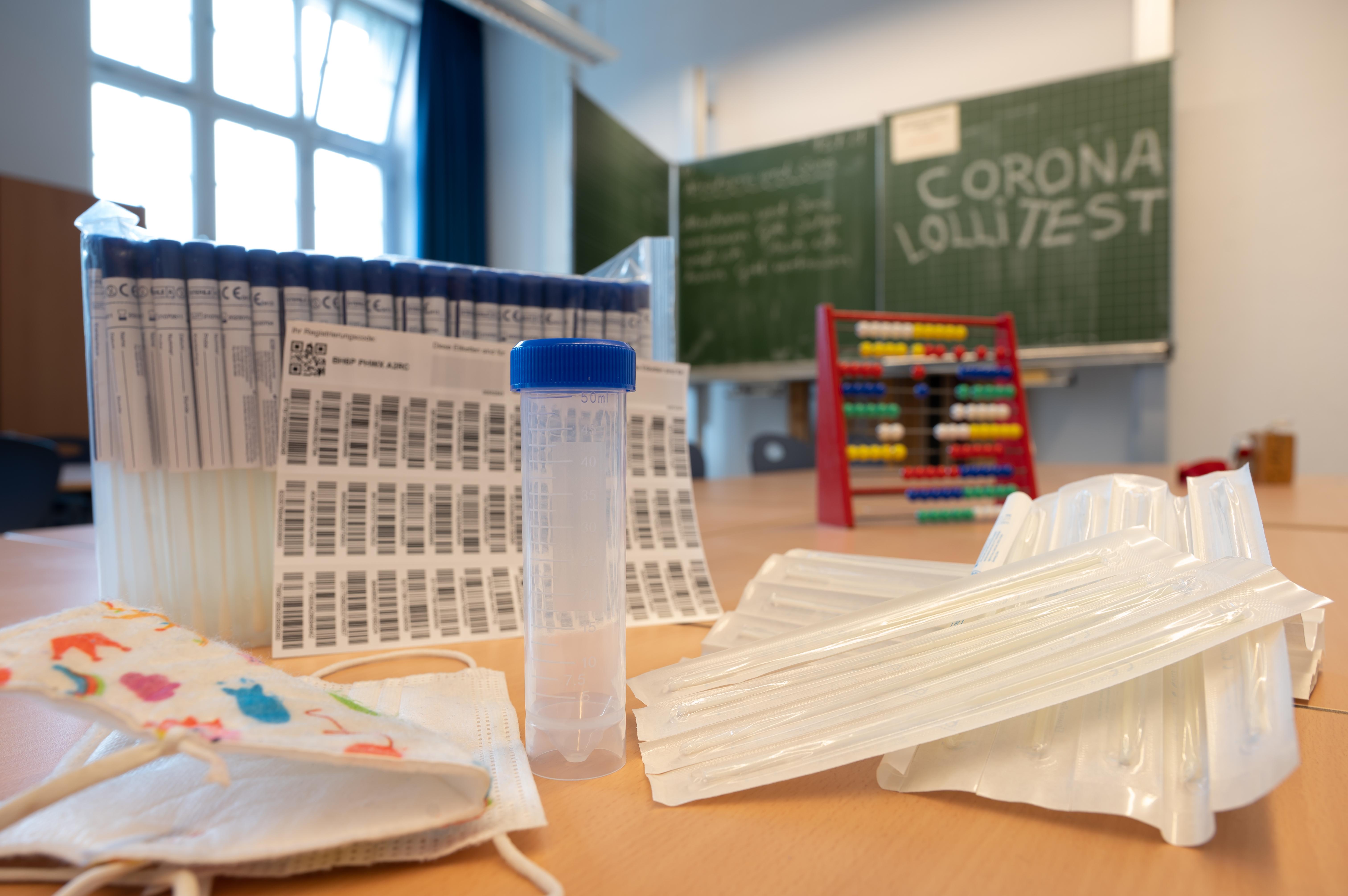 Ein komplettes, unbenutztes Set des sogenannten "Lolli-Test" (PCR-Pooltest) steht im Klasenzimmer einer bayerischen Grundschule. | Bild:pa/dpa/Peter Kneffel