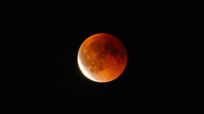 Ein blutroter Mond mit einer schmalen Sichel aus Sonnenlicht links unten: Ende der Mondfinsternis am Abend des 07. September 2025 über Berlin. | Bild: picture alliance / Rainer Keuenhof | Rainer Keuenhof Ein blutroter Mond mit einer schmalen Sichel aus Sonnenlicht links unten: Ende der Mondfinsternis am Abend des 07. September 2025 über Berlin.