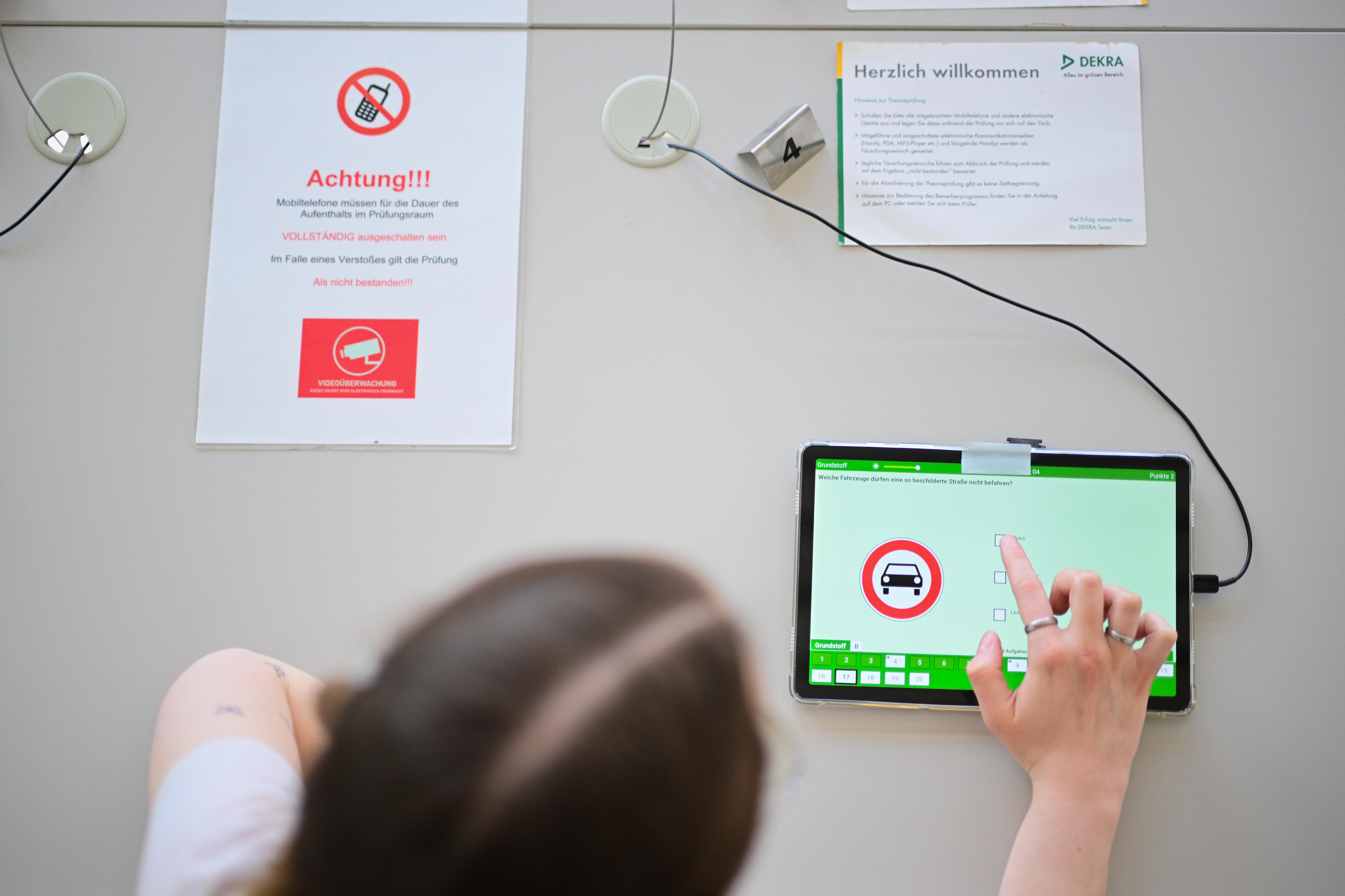 Eine Frau beantwortet eine Frage der theoretischen Prüfung des Führerscheins. 