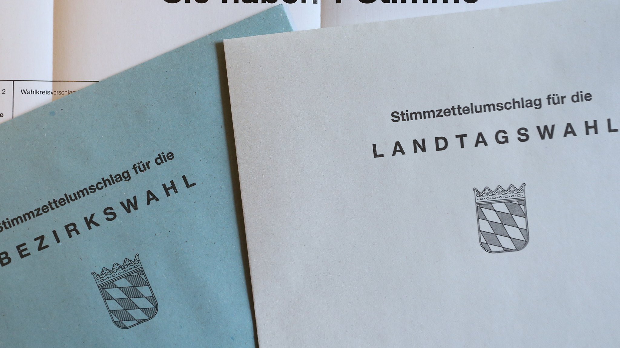 Die Umschläge für die Stimmzettel: Landtagswahl (weiß), Bezirkswahl (blau). Die Umschläge mit den Stimmzetteln verschicken Sie in dem großen roten Umschlag.