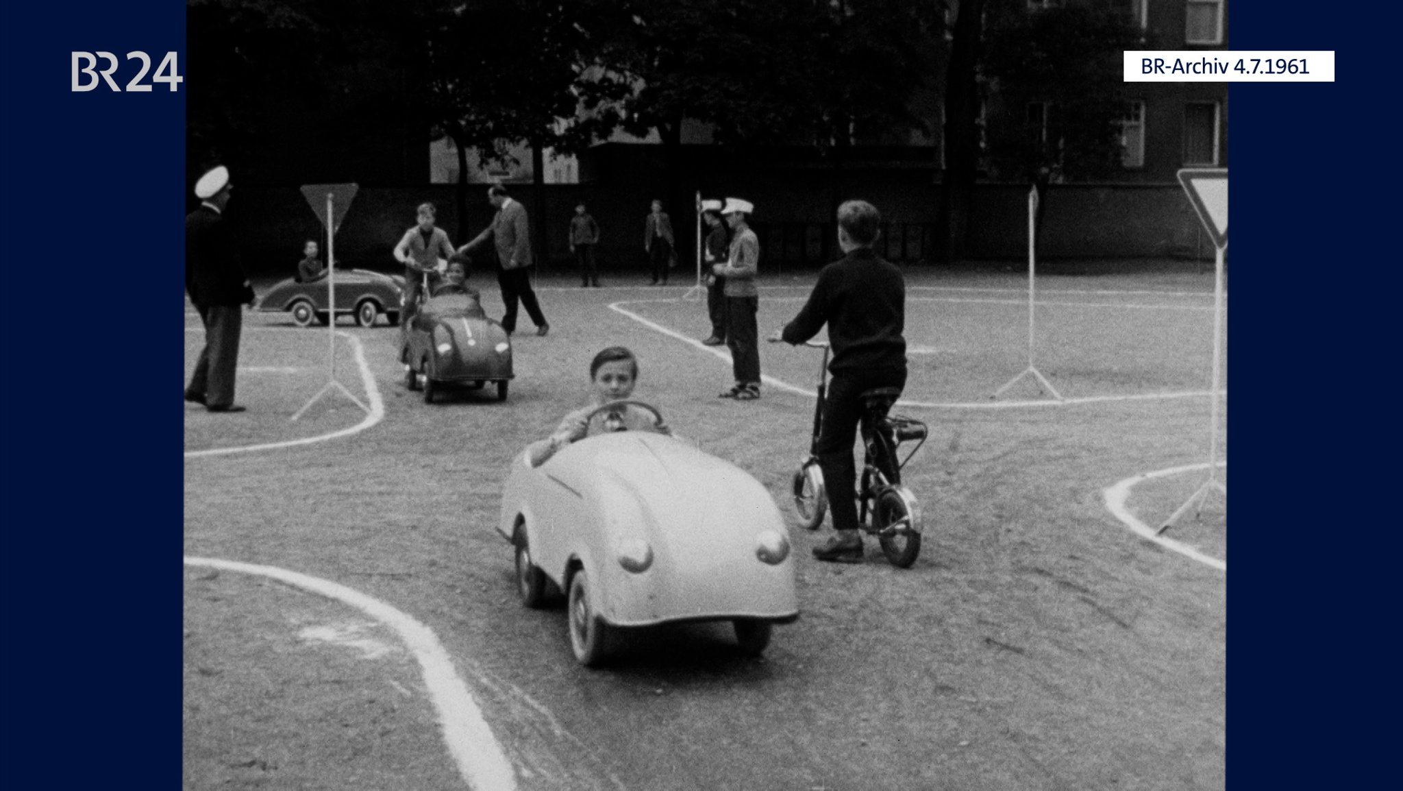 Kinder in Miniaturautos im Verkehrsparcours