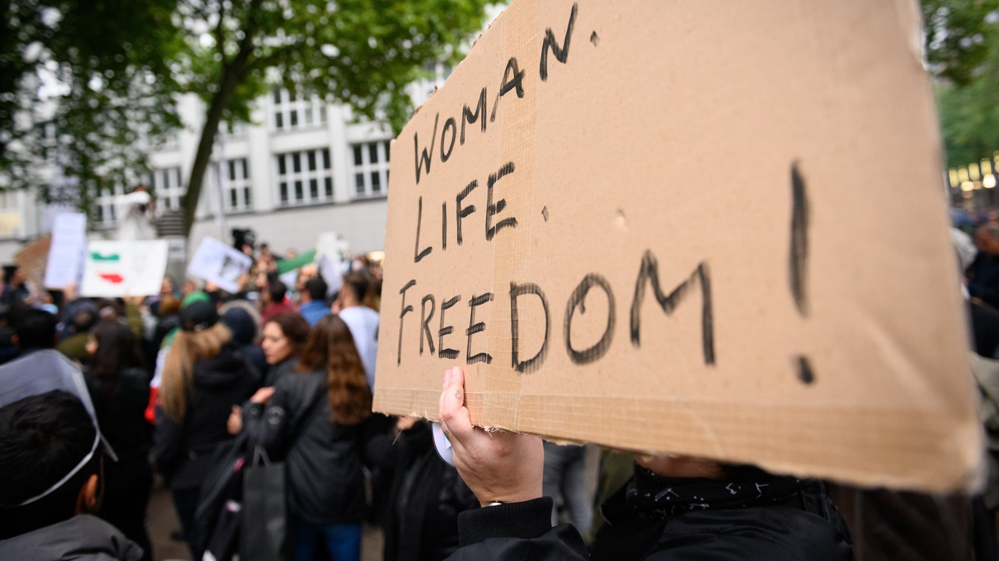 Plakat mit der Aufschrift "Women. Life. Freedom!" auf einer Solidaritätskundgebung mit den Protestierenden im Iran (Symbolbild)