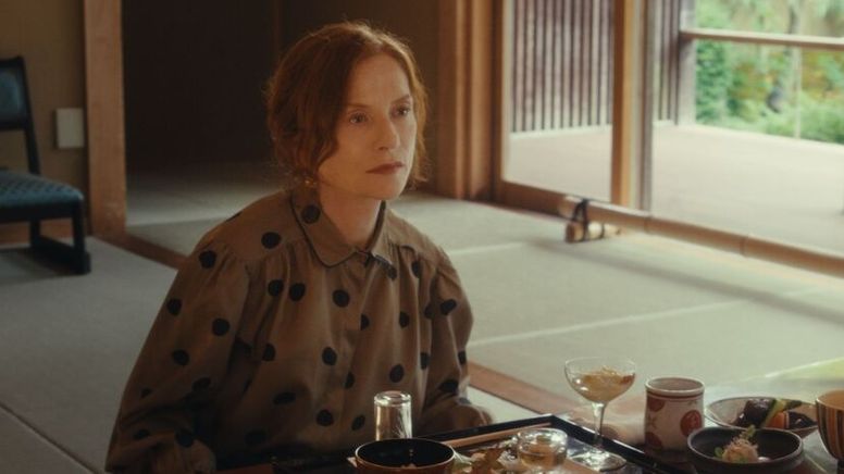 In ihrer Rolle als Schriftstellerin Sidonie Perceval sitzt Isabelle Huppert an einem Tisch mit japanischem Essen und schaut ins Leere. | Bild:Lupa Film