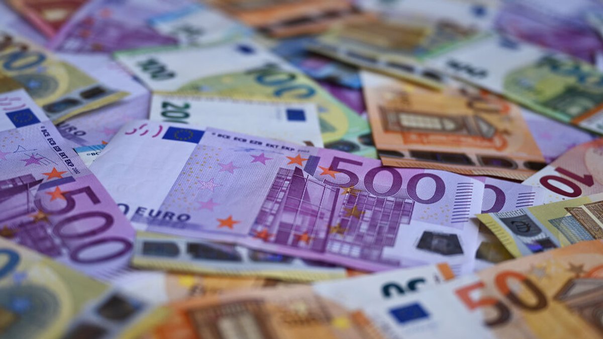 Verteilte Euro-Banknoten auf einer Fläche.