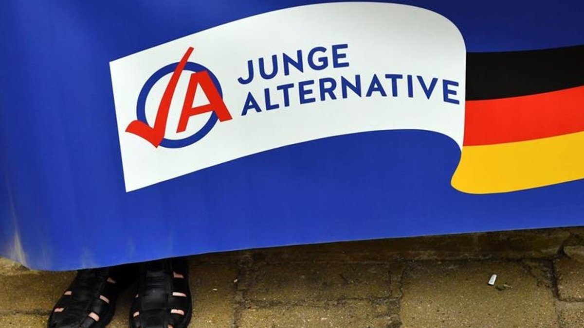 Ein Mann hält ein Plakat der AfD-Jugendorganisation Junge Alternative (JA) (Archivbild).
