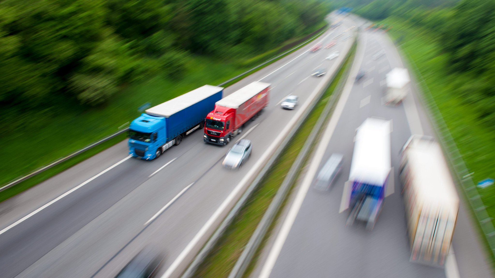 Symbolbild: Blick auf eine Autobahn mit Lkws im Überholvorgang.