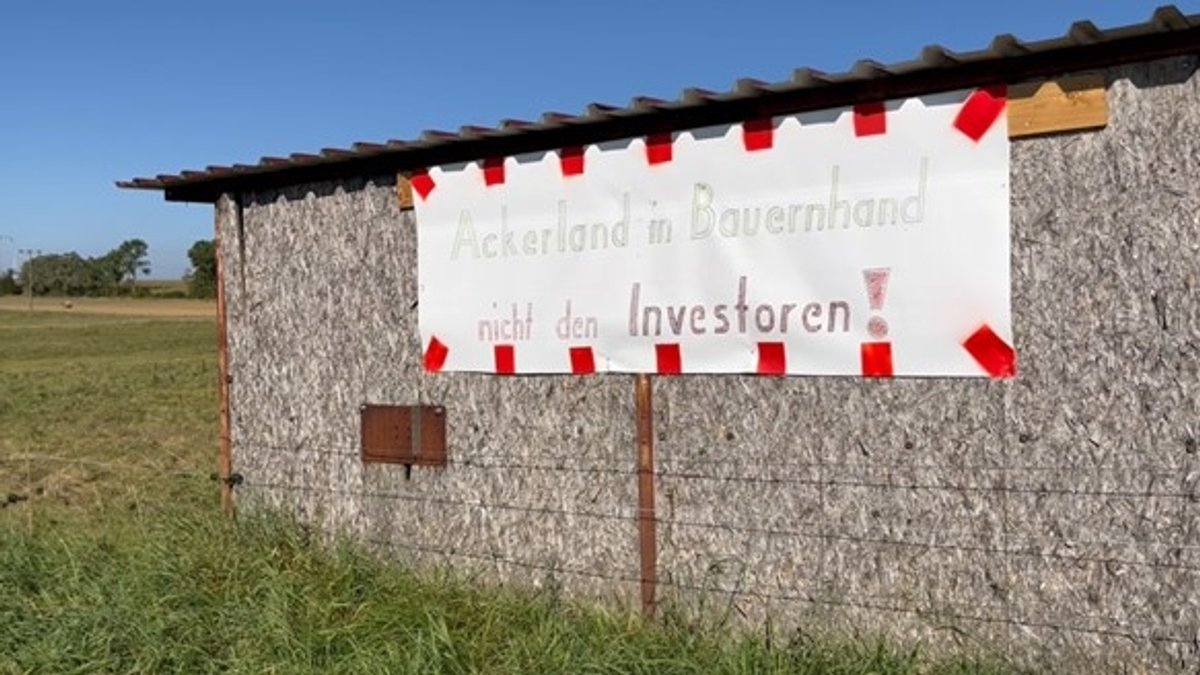 "Ackerland in Bauernhand, nicht den Investoren", steht auf einem Banner.