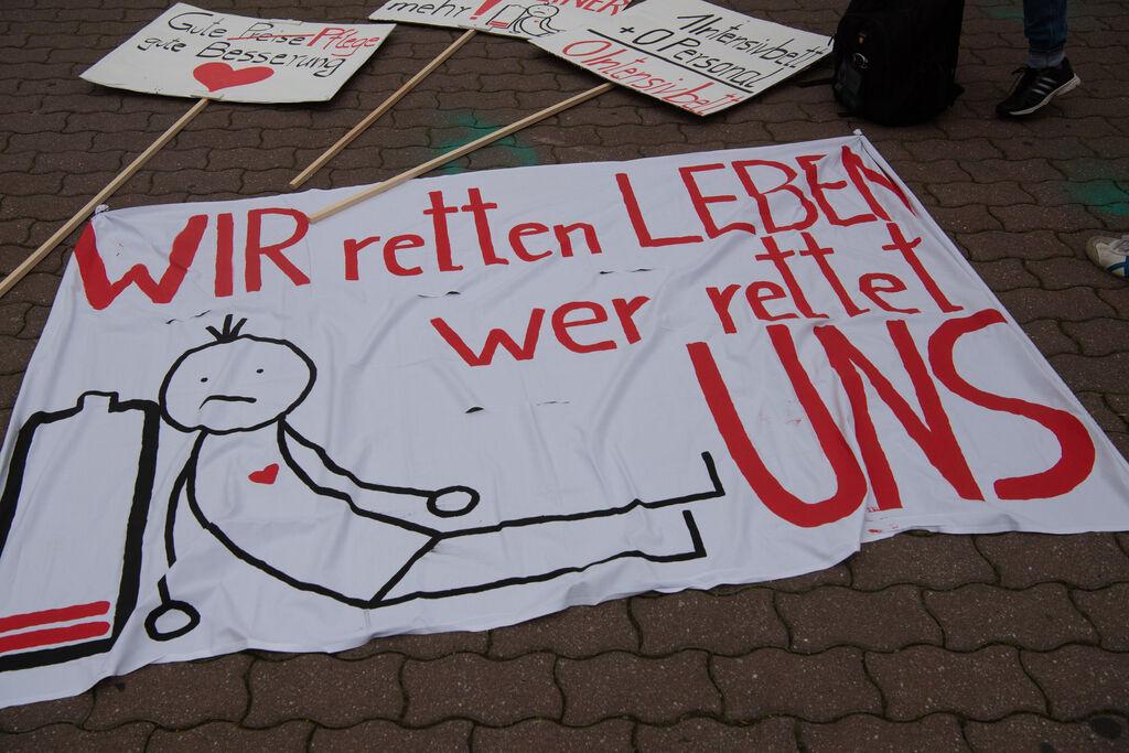 ARCHIV - 12.05.2021, Berlin: "WIR retten Leben - wer rettet UNS" steht auf einem Transparent bei einer Protestveranstaltung der Gewerkschaft verdi am Neptunbrunnen. Dort trafen sich zahlreiche Mitarbeiter aus dem medizinischen Pflegebereich. (zu dpa: «Diakonie und Caritas fordern Hilfe für die Altenpflege») Foto: Paul Zinken/dpa-Zentralbild/dpa +++ dpa-Bildfunk +++