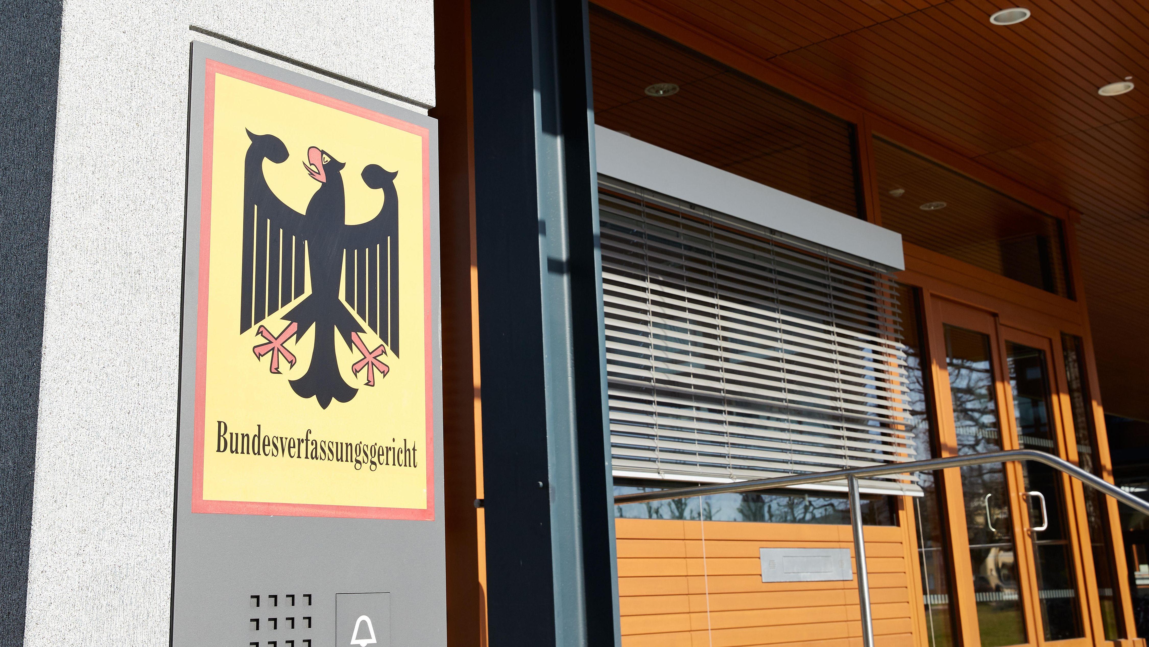 Eingang des Bundesverfassungsgerichts mit großem Türschild, dem Bundesadler und der Aufschrift "Bundesverfassungsgericht".