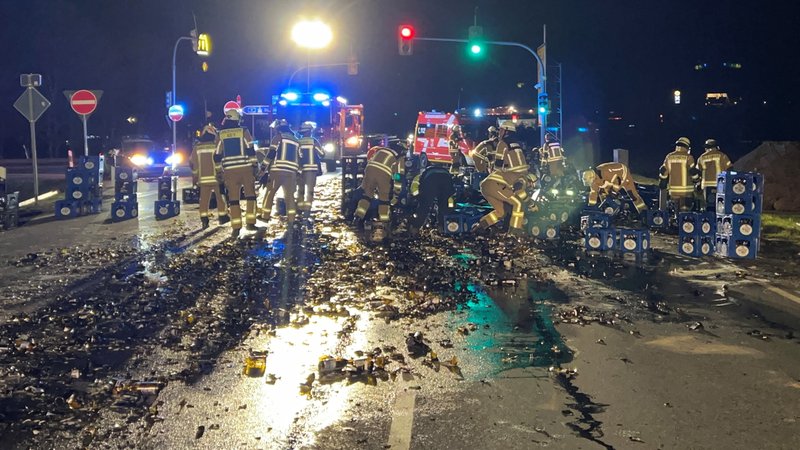 Eine Straße ist nachts mit zerbrochenen Bierflaschen übersäht, Feuerwehrleute räumen auf. | Bild: Polizei Eine Straße ist nachts mit zerbrochenen Bierflaschen übersäht, Feuerwehrleute räumen auf.