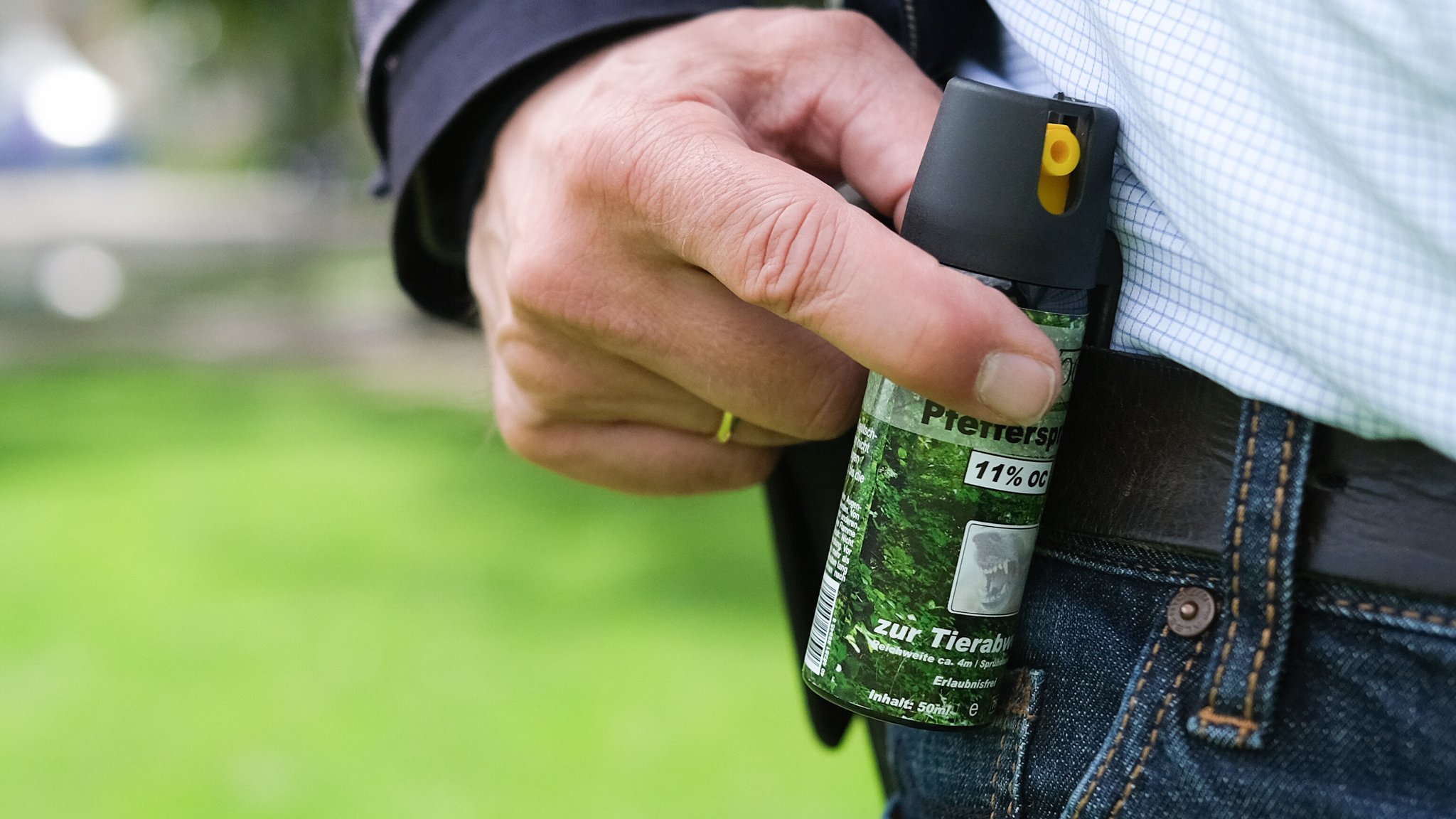 Ein Mann hält ein Pfefferspray in der Hand