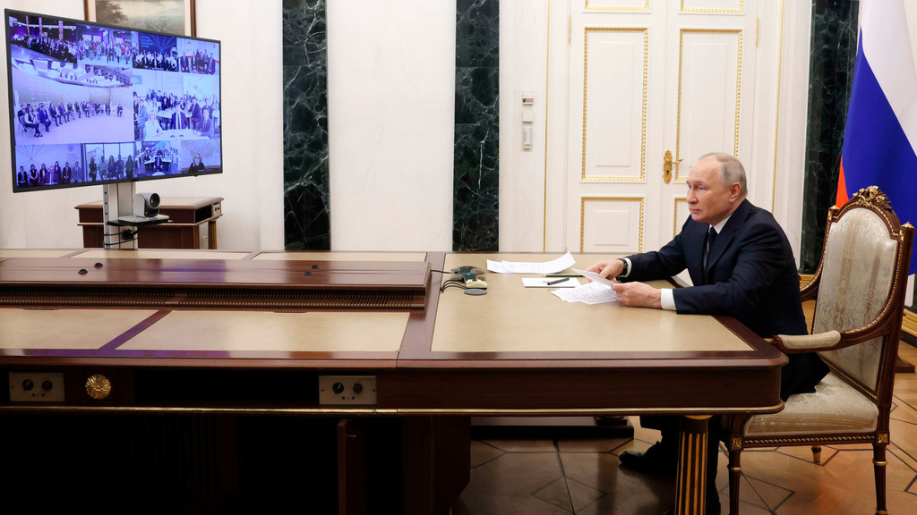 Der russische Präsident sitzt an einem Schreibtisch