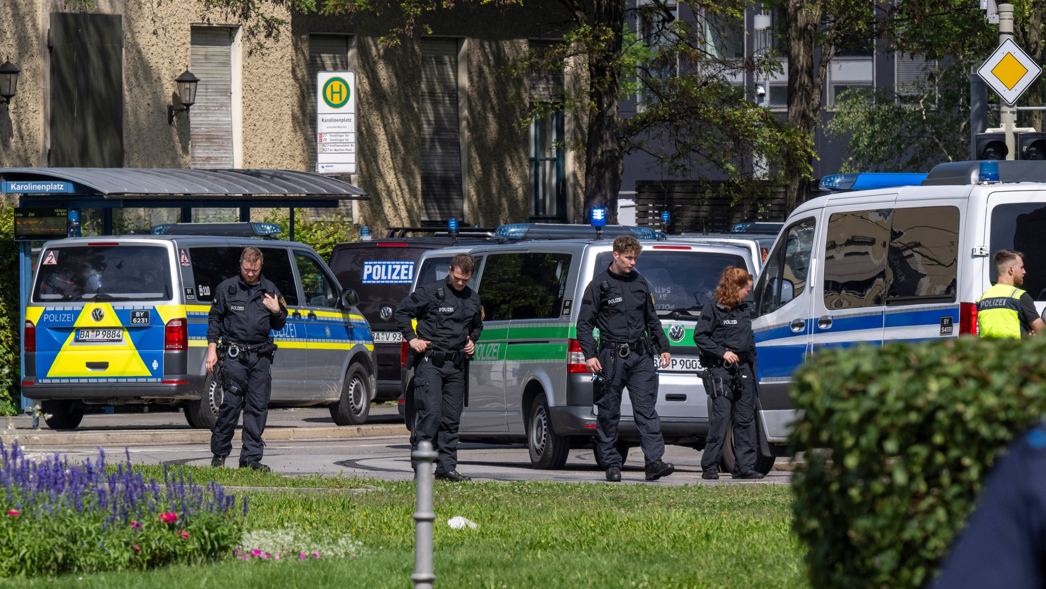 Polizei durchsucht die Blumenbeete und die Straße am Karolinen-Platz nach Spuren. 