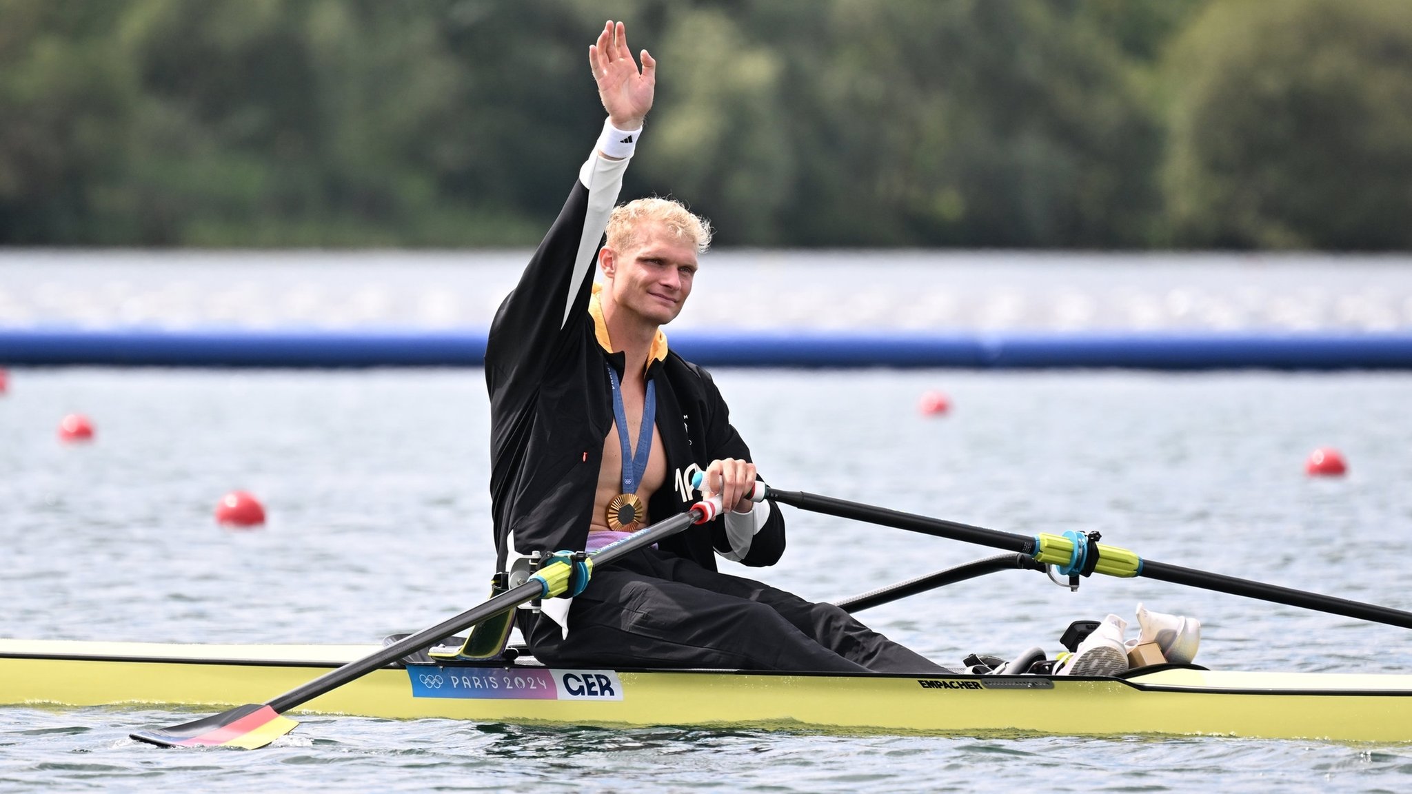 03.08.2024, Frankreich, Vaires-Sur-Marne: Olympia, Paris 2024, Rudern, Einer, Männer, Finale, Vaires-sur-Marne Nautical Stadium, Oliver Zeidler aus Deutschland sitzt nach der Siegerehrung in seinem Boot und winkt. 