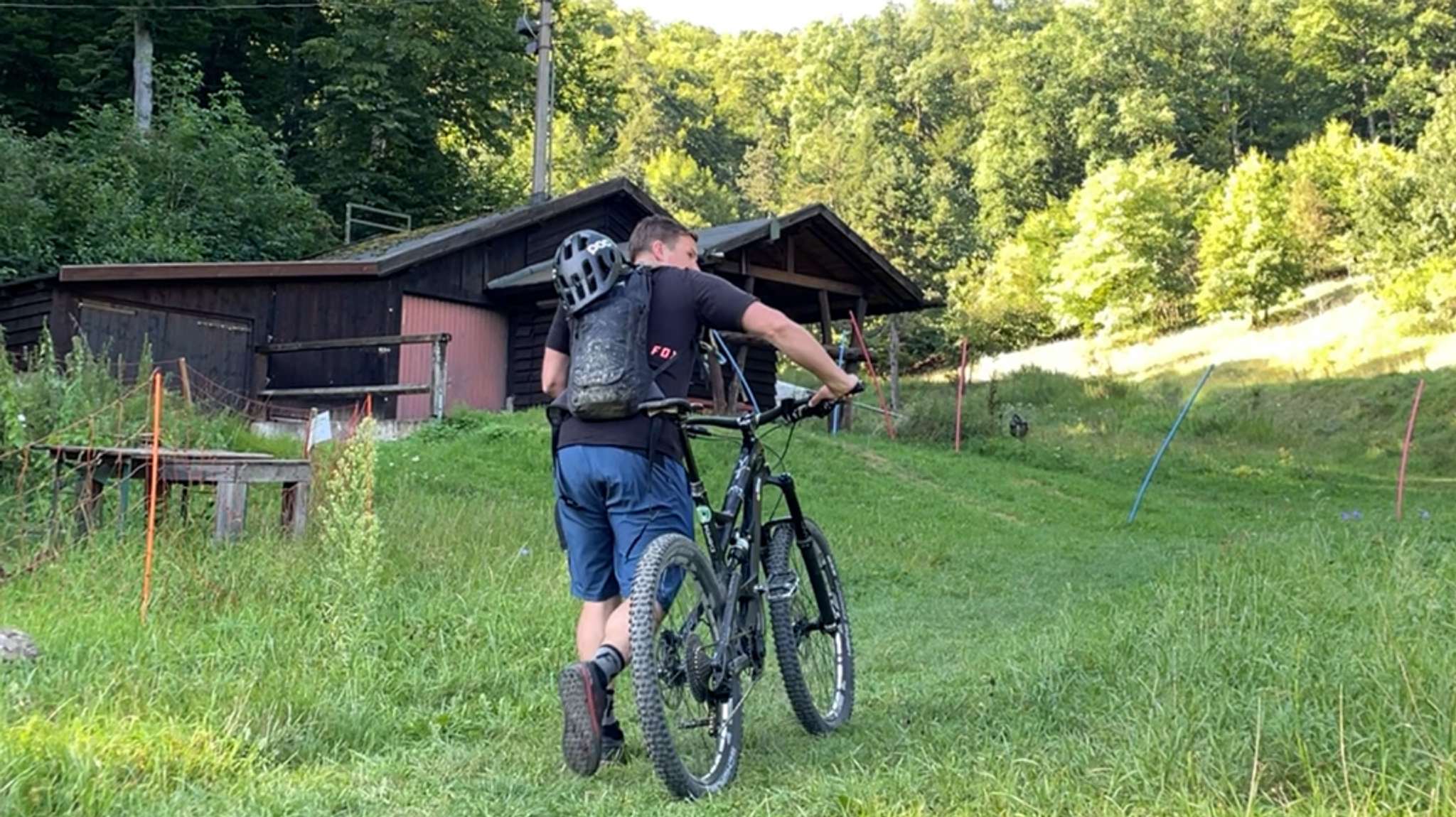 Ein Mann schiebt sein Mountainbike den Berg hinauf.