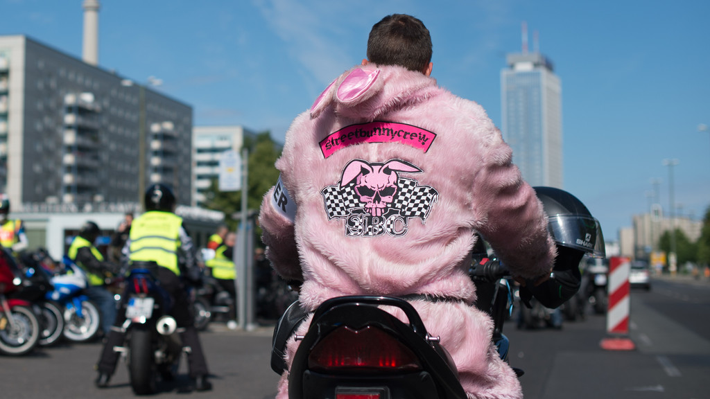 Ein Mann in einem rosa Hasenkostüm mit der Aufschrift Streetbunnycrew auf einem Motorrad