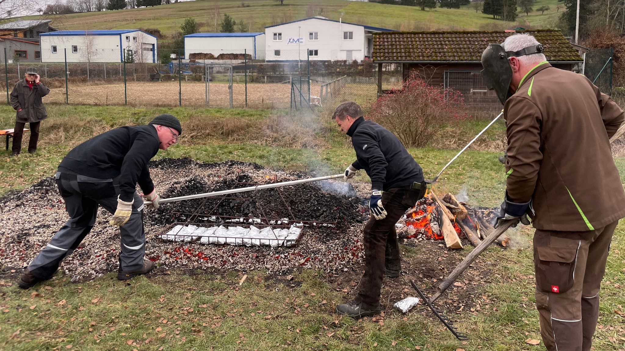 Das in Alufolie gewickelte Lakefleisch wird in Körben auf die heiße Glut gelegt und luftdicht bedeckt.