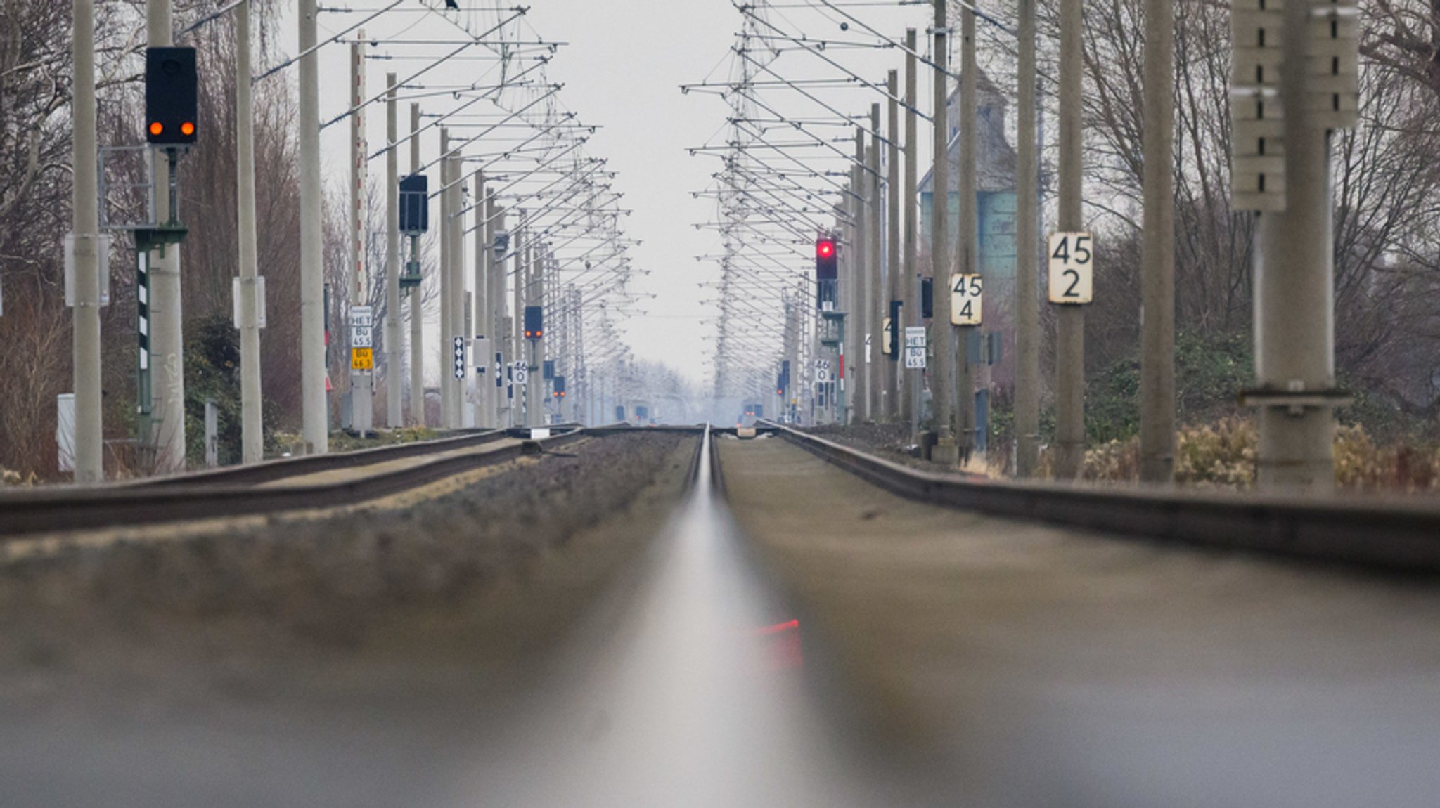 Ein rotes Signal leuchtet auf einer Bahnstrecke.