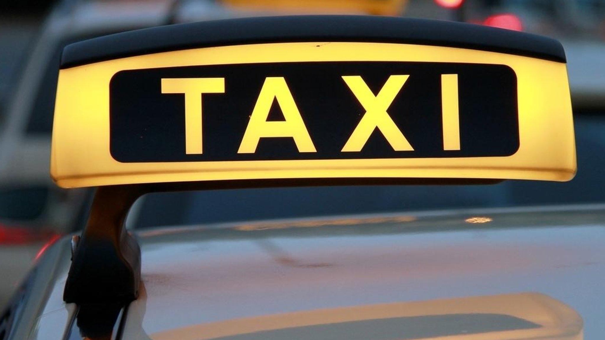 Ein Taxischild, montiert auf dem Dach eines Autos. 