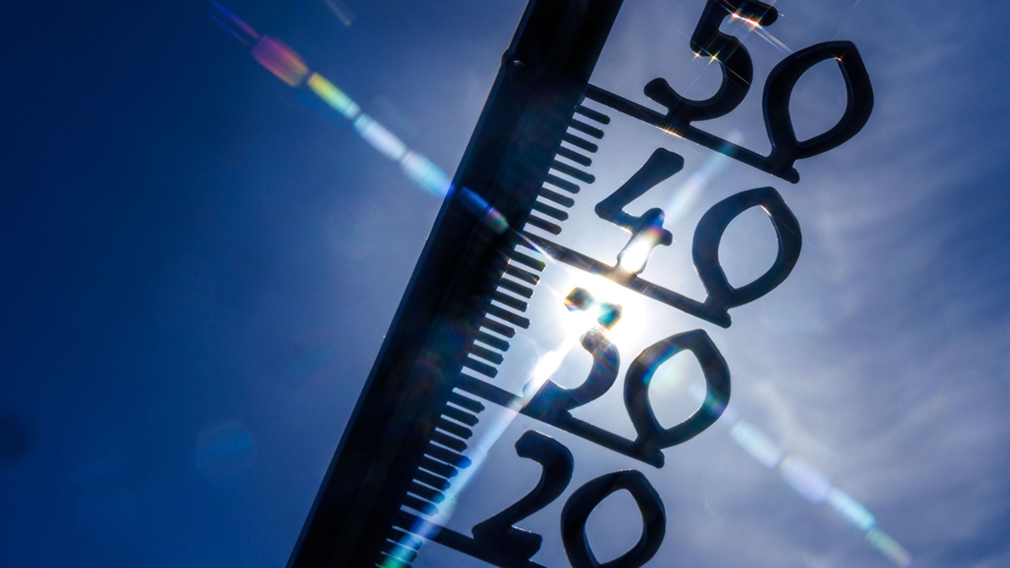  Ein Außenthermometer hinter einem blauen Himmel (Symbolbild).