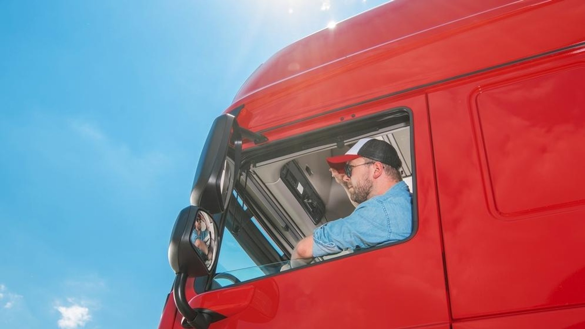 Ein Mann sitzt in einem roten Lkw.