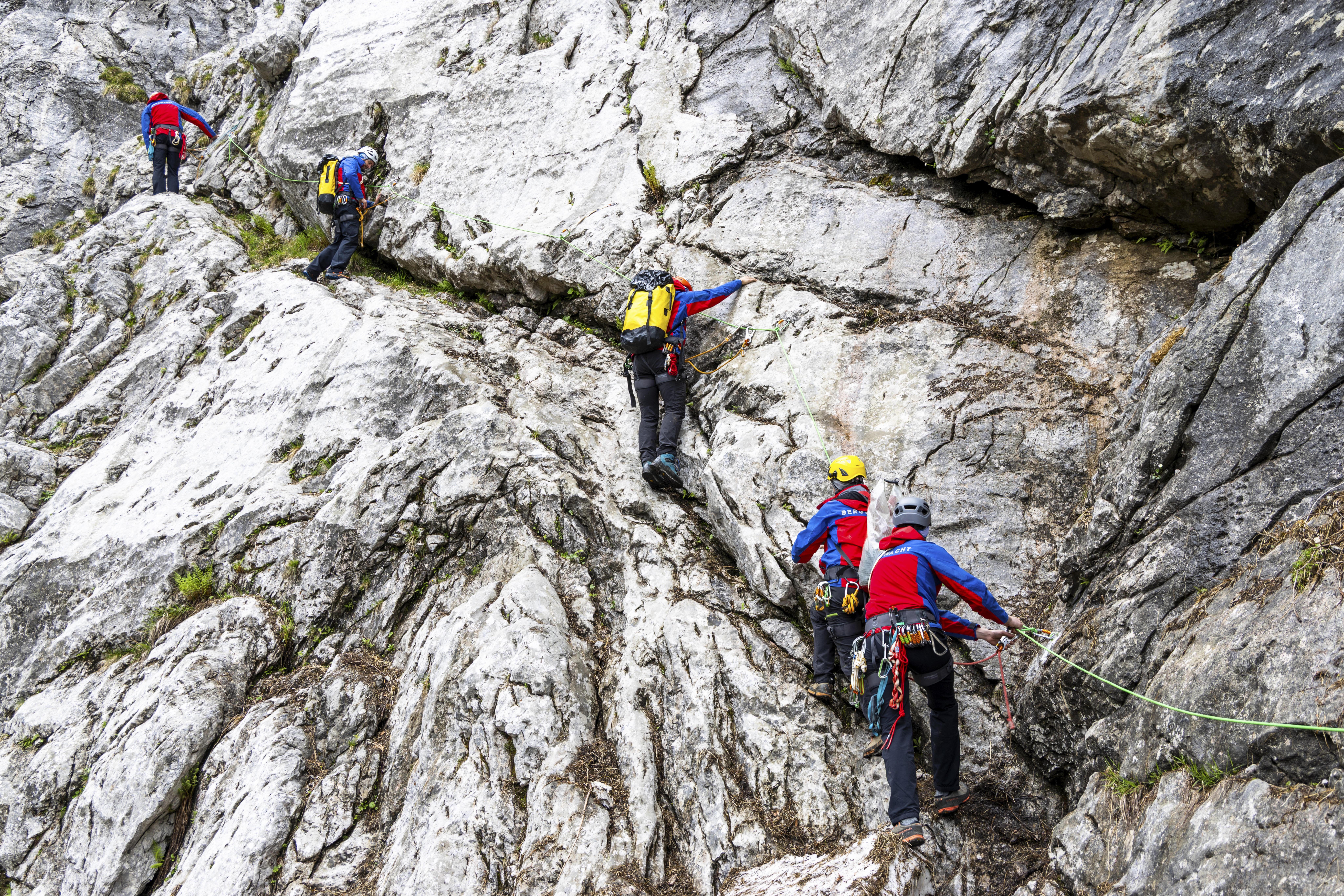 Bergretter der Bergwacht Bayern klettern an einer steilen Felswand am Hohen Göll in den Berchtesgadener Alpen. 