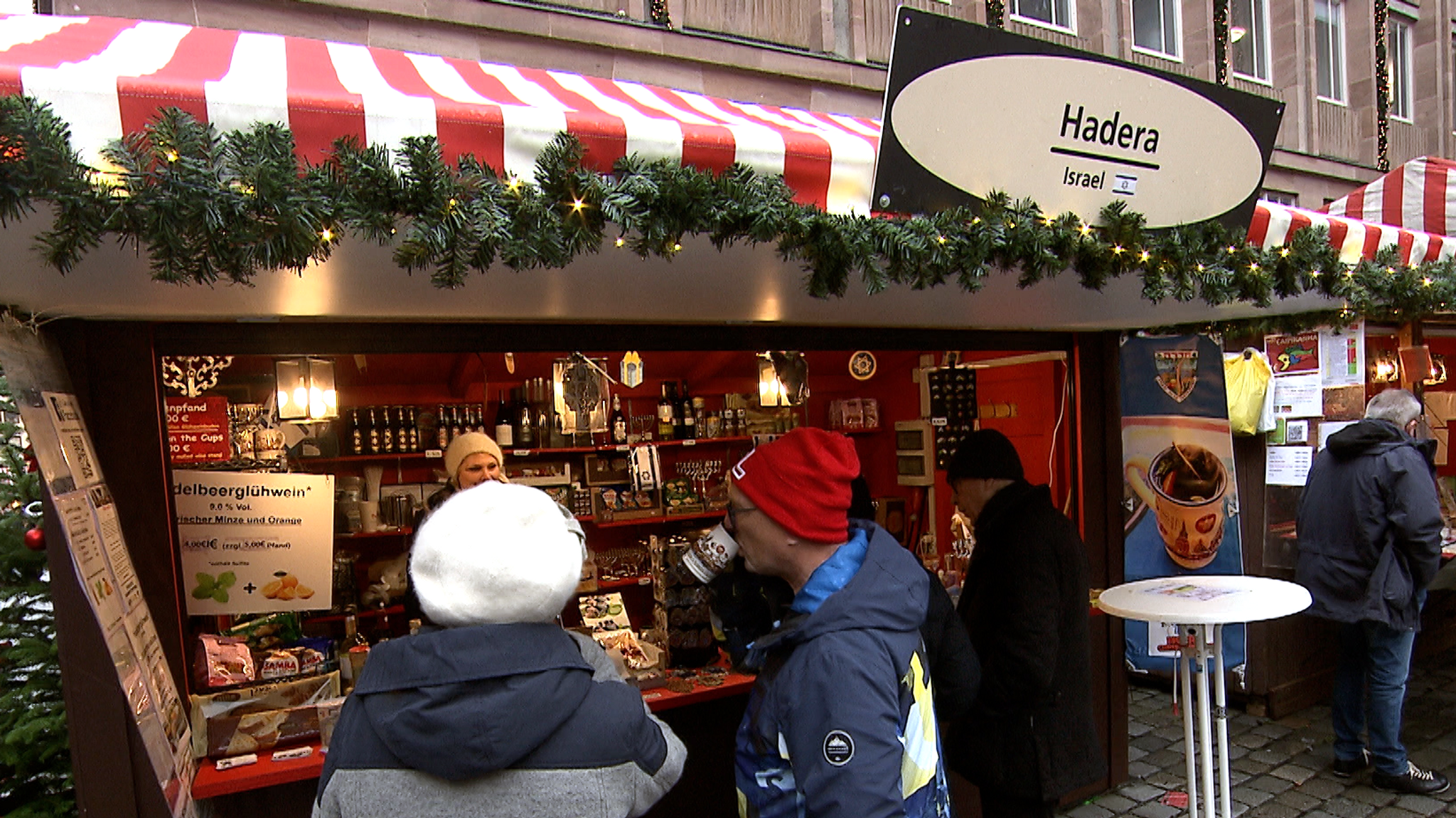 Geschmückter Stand auf dem Nürnberger Christkindlesmarkt mit rot-weiß-gestreiftem Dach.