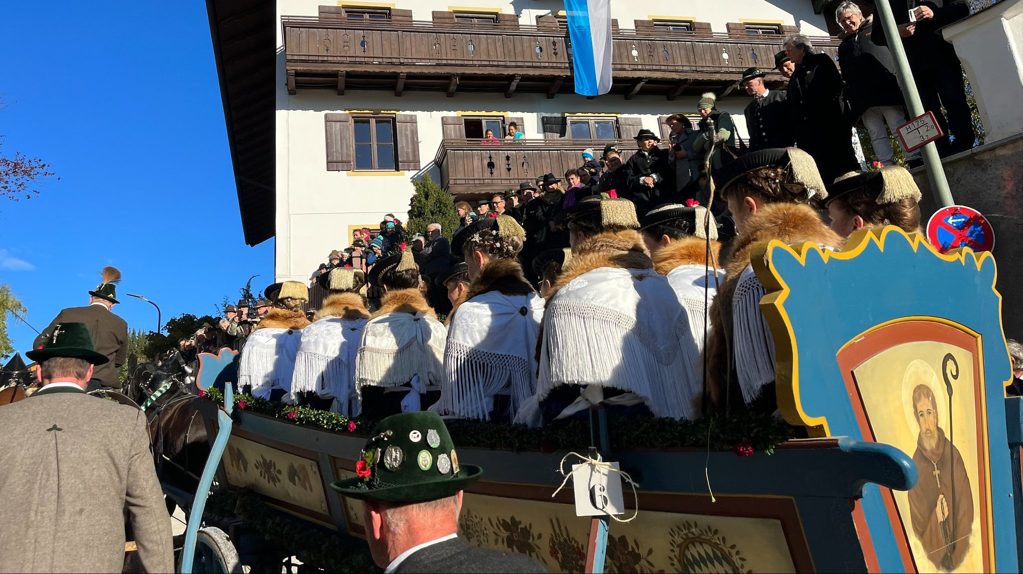 Zu sehen ist der Leonhardi-Zug mit Menschen in Tracht, teilweise in Pferdekutschen stehend