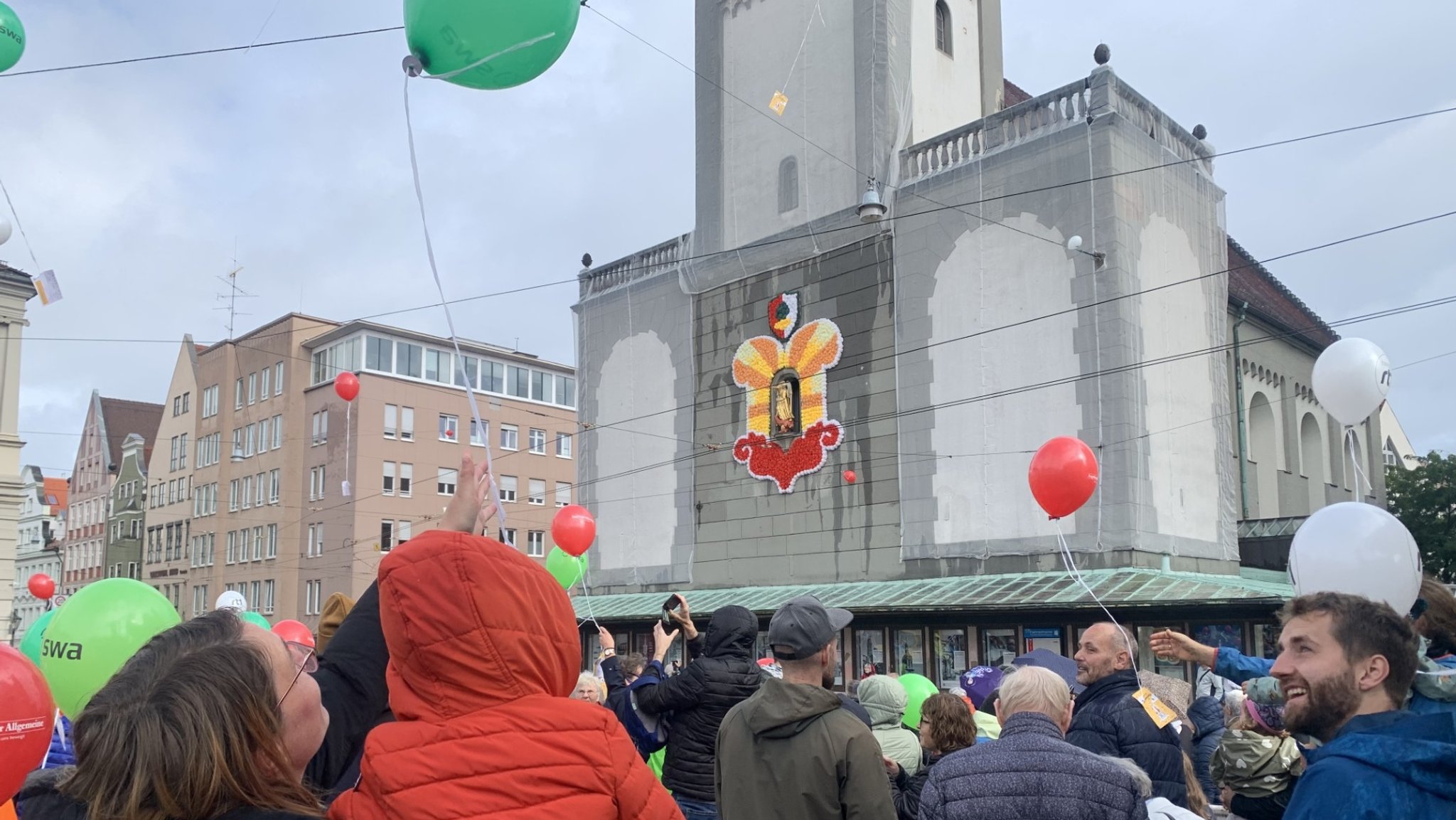 Beim Turamichelefest in Augsburg steigen rote, grüne und weiße Luftballone auf (Samstag, 28.09.2024).