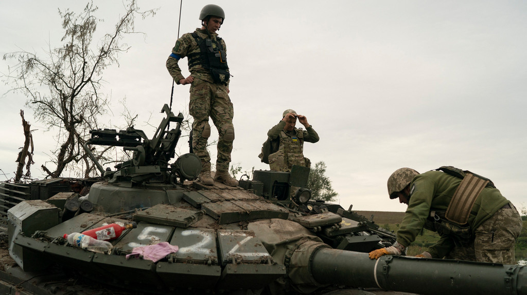 Ukrainische Soldaten standen am Samstag auf einem zerstörten russischen Panzer in einem zurückeroberten Gebiet in der Region Charkiw.