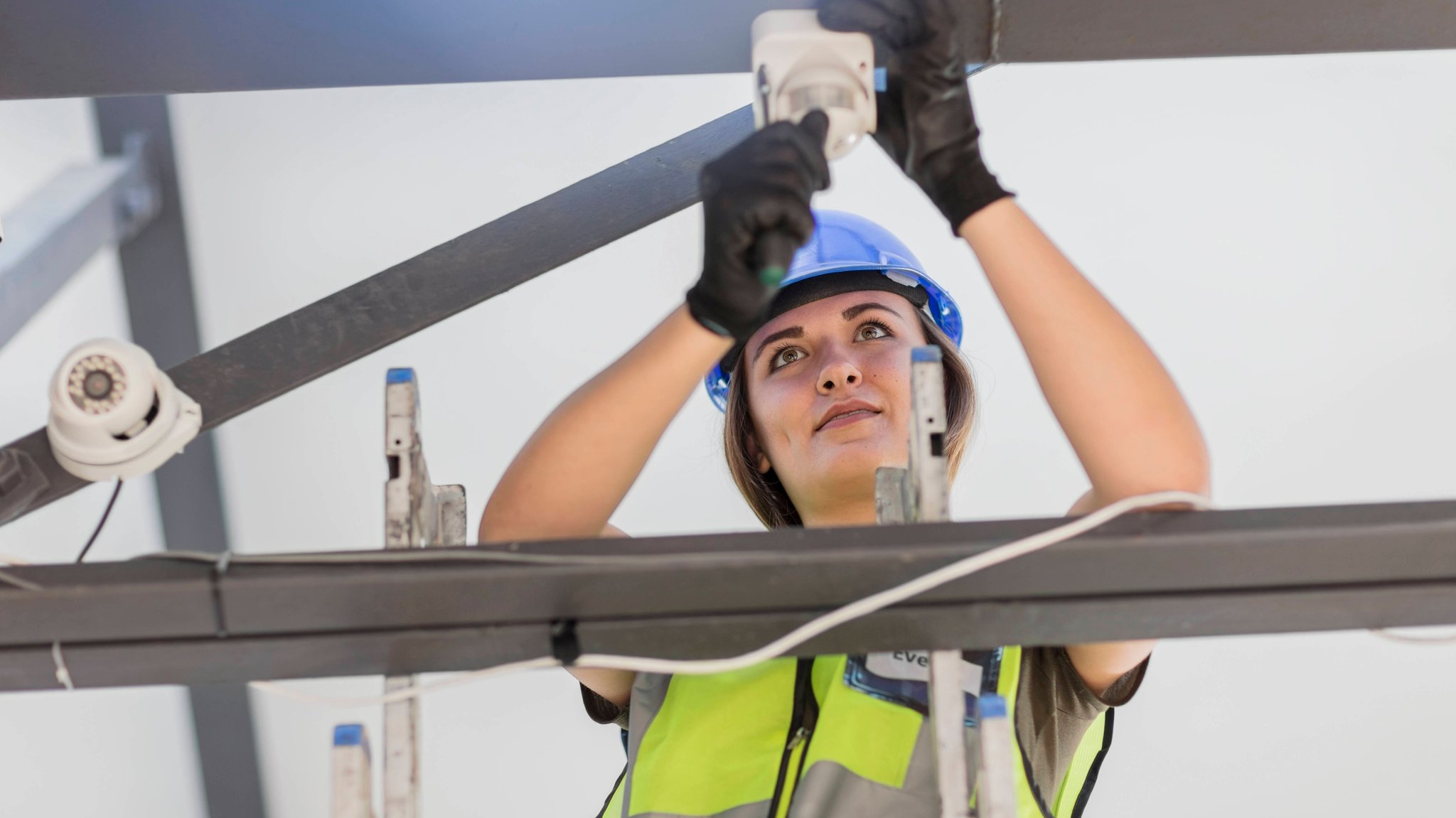 Eine junge Elektrikerin installiert eine Lampe.