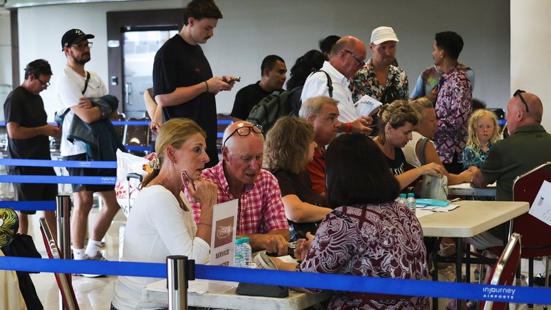 Urlauber sitzen an Info-Tischen am Flughafen Dubai. | Bild: REUTERS/Johannes Christo Urlauber sitzen an Info-Tischen am Flughafen Dubai.