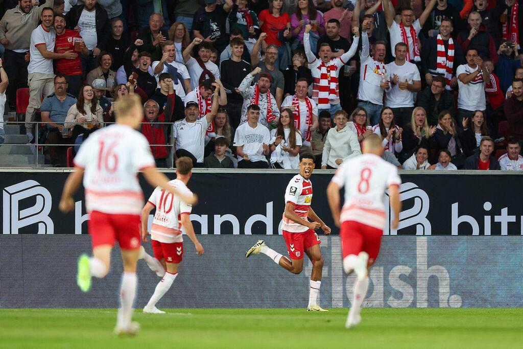 24.05.2024, Bayern, Regensburg: Fußball: 2. Bundesliga - Relegation, Jahn Regensburg - SV Wehen Wiesbaden, Relegation, Hinspiel, Jahnstadion Regensburg. Der Regensburger Noah Ganaus (M) jubelt nach seinem Tor zum 1:0. Foto: Daniel Löb/dpa - WICHTIGER HINWEIS: Gemäß den Vorgaben der DFL Deutsche Fußball Liga bzw. des DFB Deutscher Fußball-Bund ist es untersagt, in dem Stadion und/oder vom Spiel angefertigte Fotoaufnahmen in Form von Sequenzbildern und/oder videoähnlichen Fotostrecken zu verwerten bzw. verwerten zu lassen. +++ dpa-Bildfunk +++