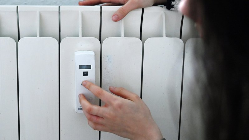 (Symbolbild): Eine Frau berührt einen Heizkörper in einer Wohnung, an dem ein Heizkostenverteiler angebracht ist. | Bild: pa/dpa/Elisa Schu (Symbolbild): Eine Frau berührt einen Heizkörper in einer Wohnung, an dem ein Heizkostenverteiler angebracht ist.