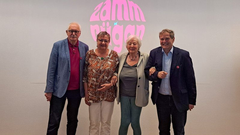 Ehemalige Politiker stehen vor dem Logo der Initiative "Zammrüggn" | Bild: BR / Miriam Scholz Ehemalige Politiker stehen vor dem Logo der Initiative "Zammrüggn"