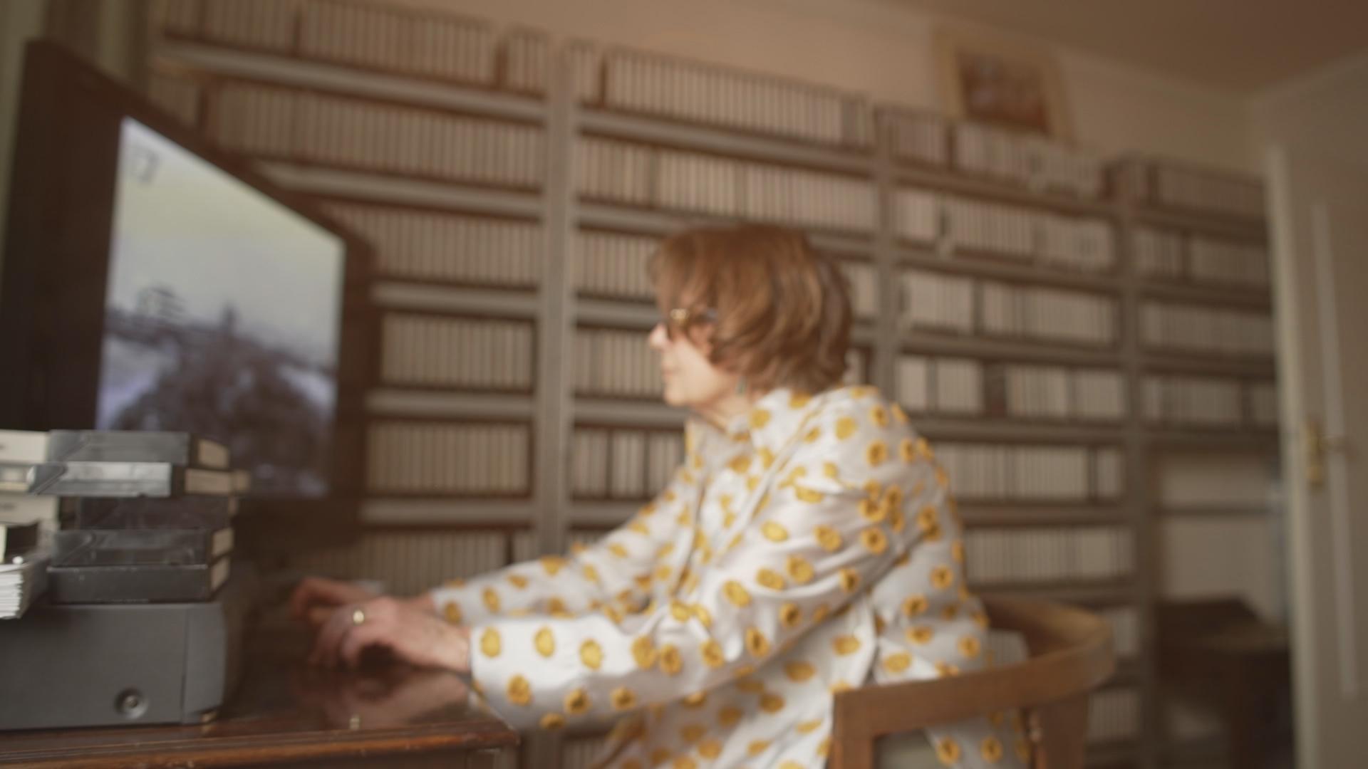 Eine Frau sichtet VHS-Kassetten.