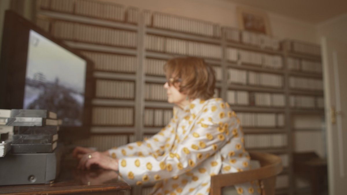 Eine Frau sichtet VHS-Kassetten.