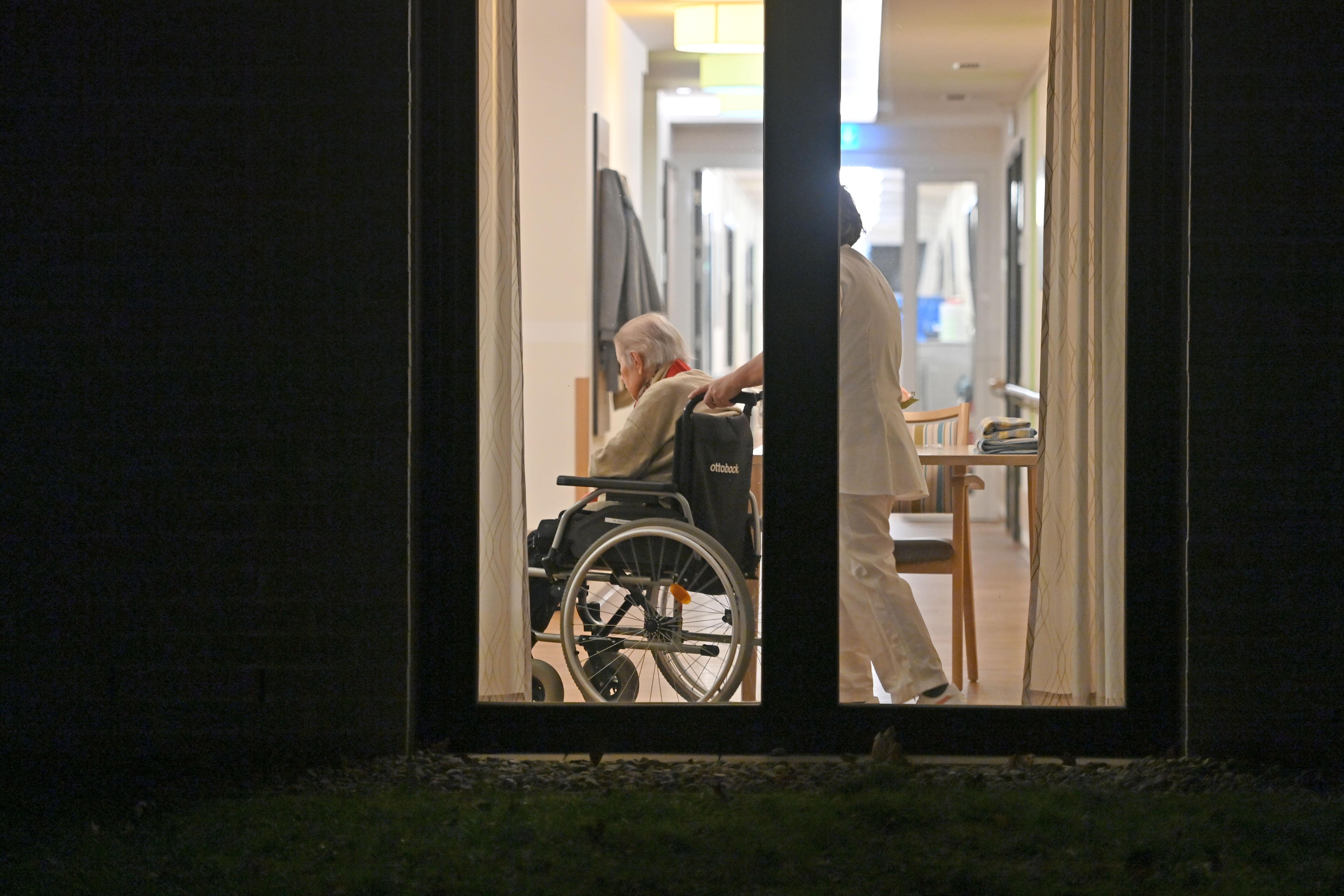 Senior im Rollstuhl mit Pflegerin