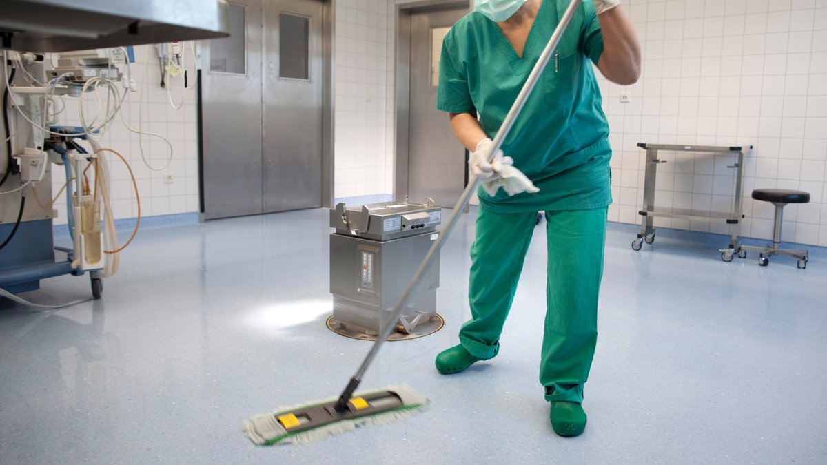 Reinigung eines Operationssaals durch eine Reinigungskraft in einem Krankenhaus