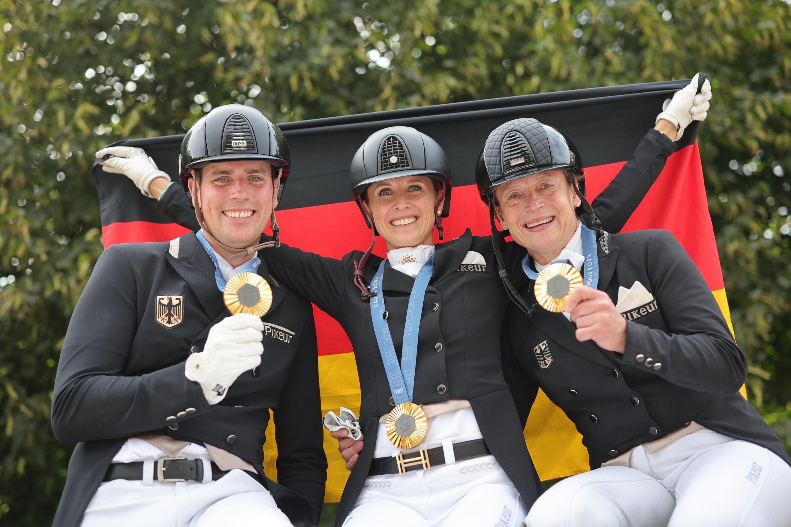 Das deutsche Dressurteam Frederic Wandres, Jessica von Bredow-Werndl und Isabell Werth (v.l.) mit Goldmedaille