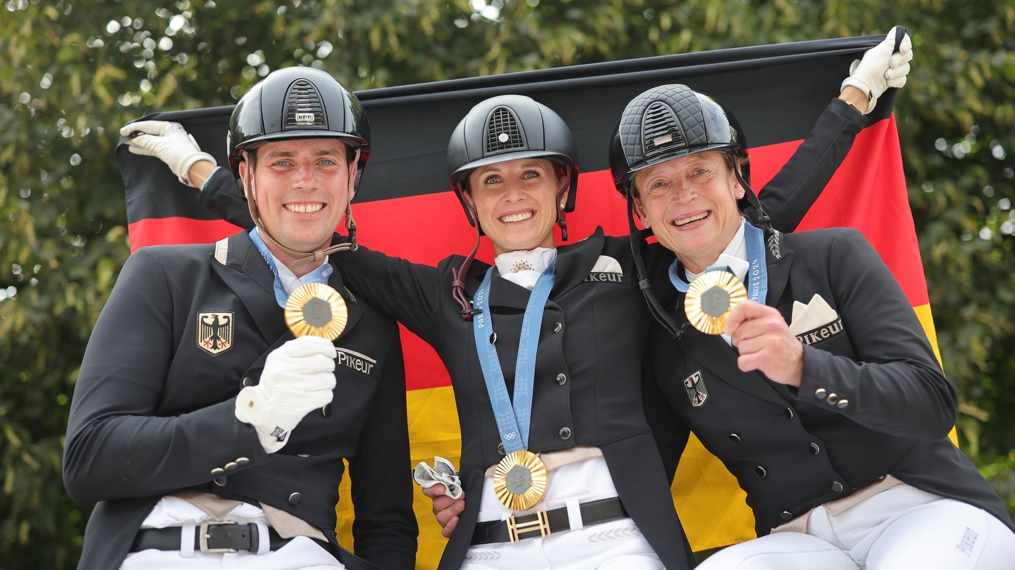 Das deutsche Dressurteam Frederic Wandres, Jessica von Bredow-Werndl und Isabell Werth (v.l.) mit Goldmedaille