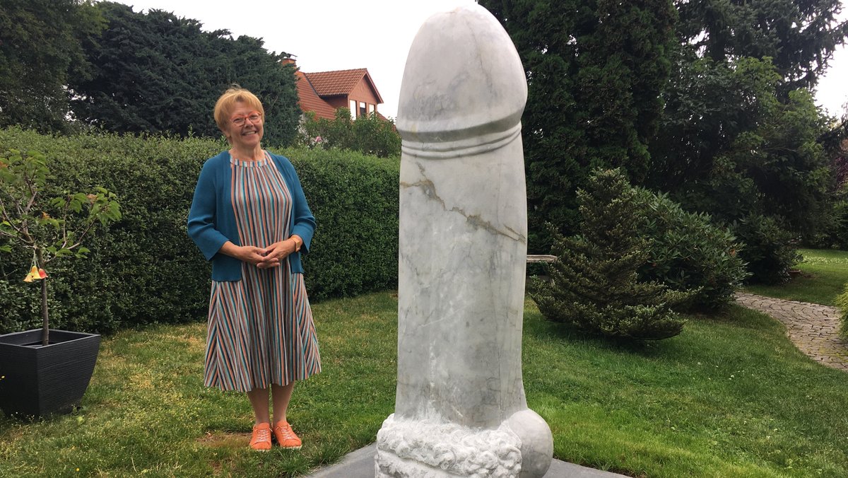 Ilona Vogel in ihrem garten in Köditz im Landkreis Hof vor dem riesigen Stein-Penis aus Wunsiedler Marmor.