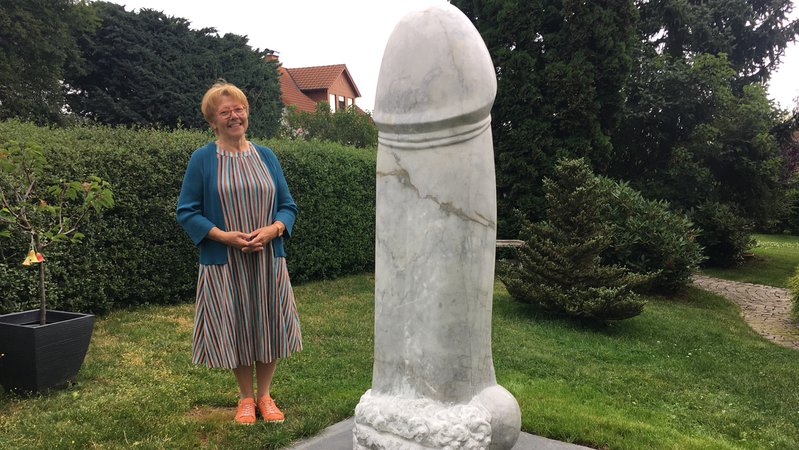 Ilona Vogel in ihrem garten in Köditz im Landkreis Hof vor dem riesigen Stein-Penis aus Wunsiedler Marmor. | Bild: BR/Tobias Burkert Ilona Vogel in ihrem garten in Köditz im Landkreis Hof vor dem riesigen Stein-Penis aus Wunsiedler Marmor.