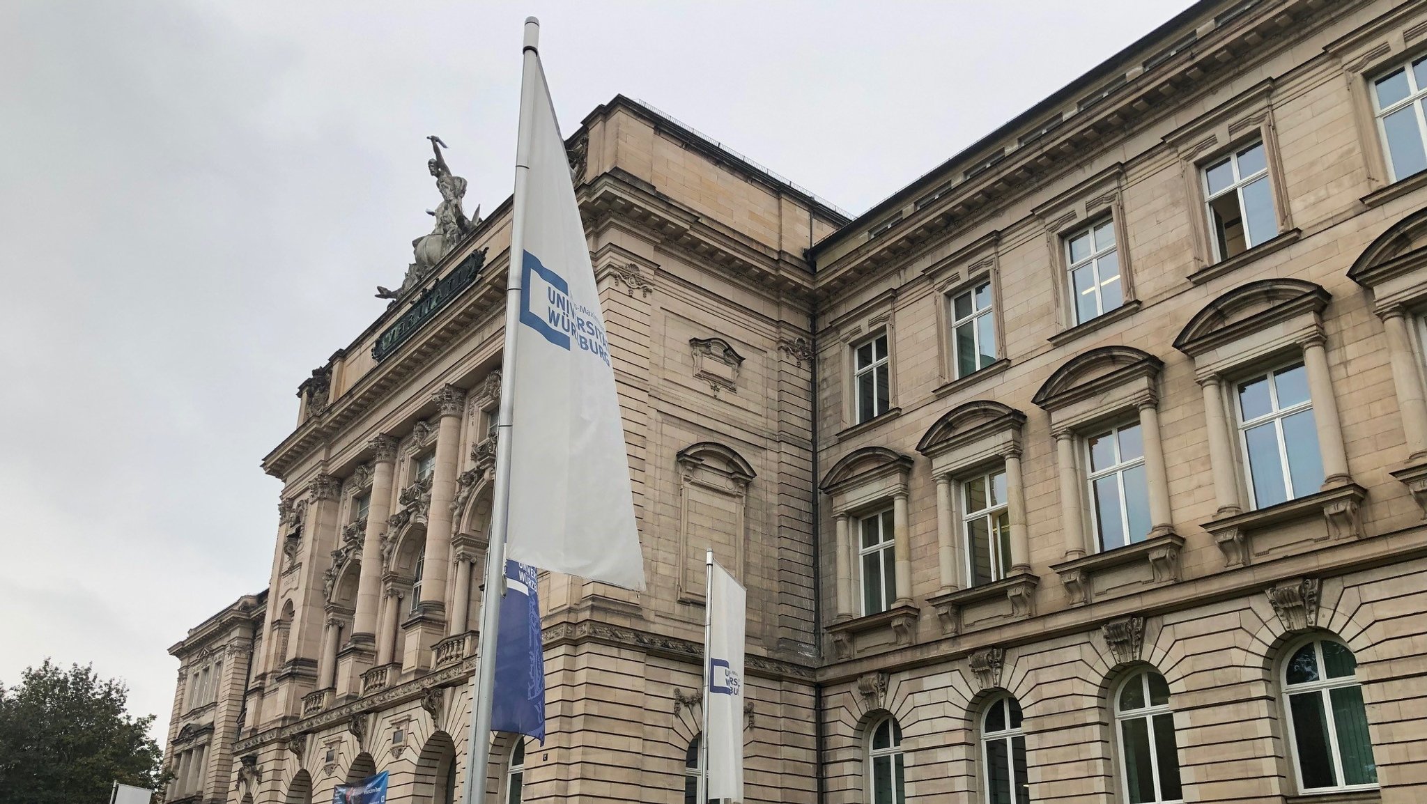 Uni Würzburg am Sanderring, davor wehende Fahnen