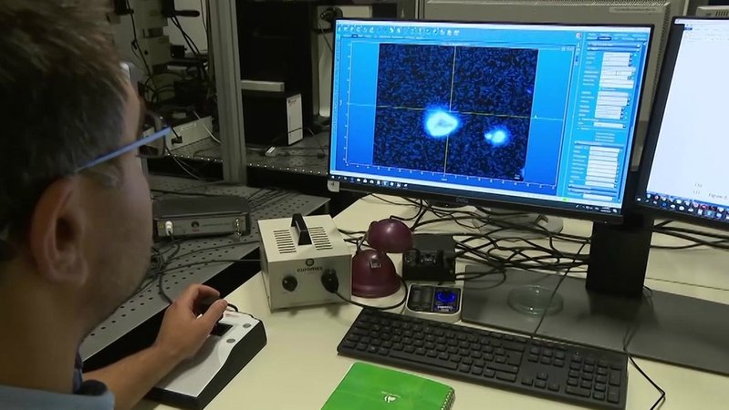Ein Forscher betrachtet Mikroplastik unter dem Mikroskop